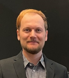 Auf dem Foto ist ein blonder Mann in Hemd und Sakko abgebildet.