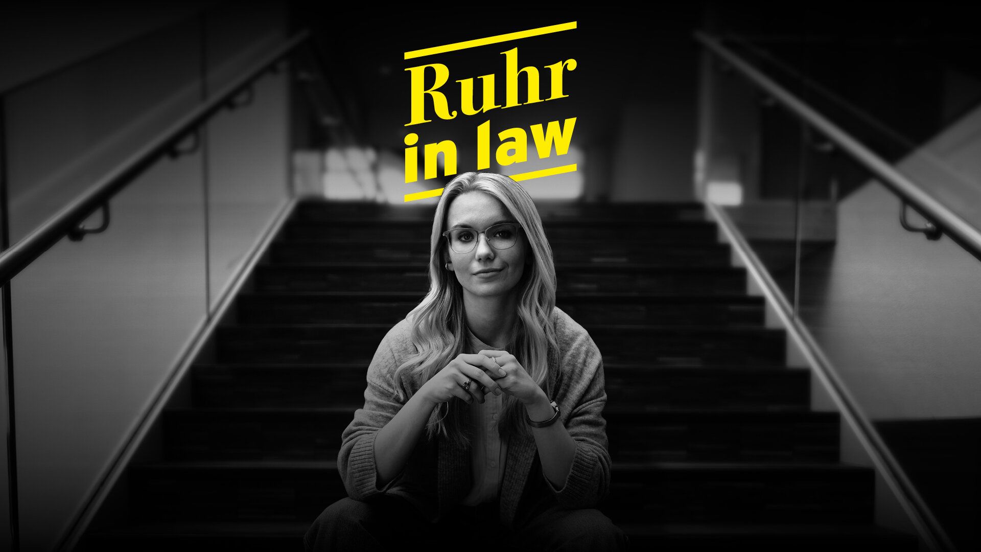 Eine Mitarbeiterin der Justiz sitzt auf einer Treppe in einer leeren großen Lagerhalle. Dazu der Text "Ruhr in law". 
