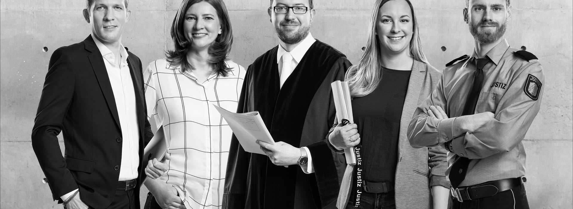 5 Mitarbeiter der Justiz NRW aus Gerichten und Staatsanwaltschaften stehen nebeneinander und lachen in die Kamera.