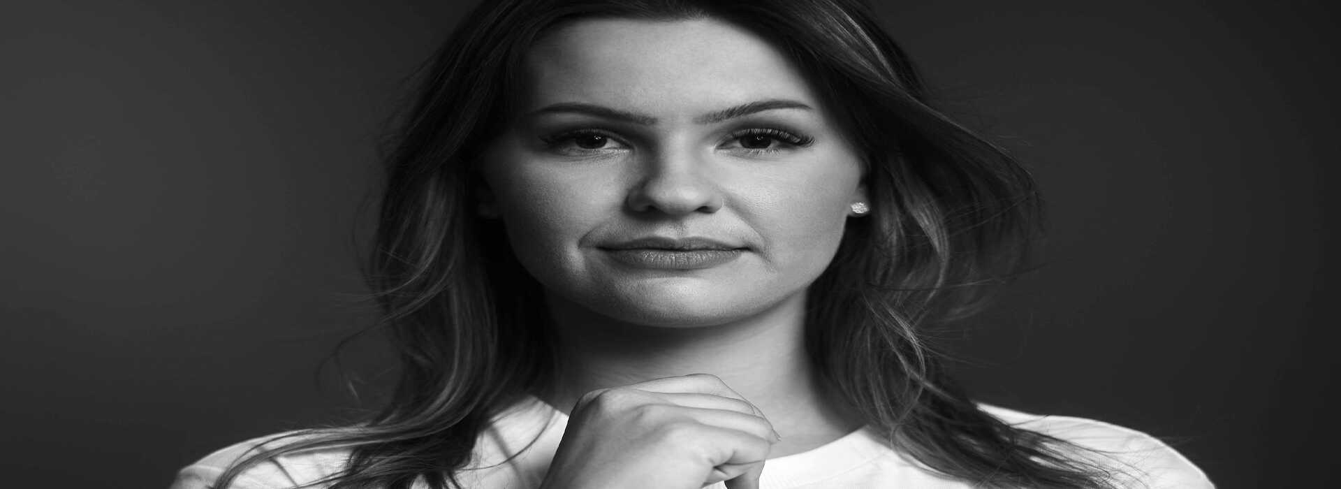 Eine Mitarbeiterin der Justiz NRW im weißen T-Shirt schaut direkt in die Kamera.n fotografiert worden.