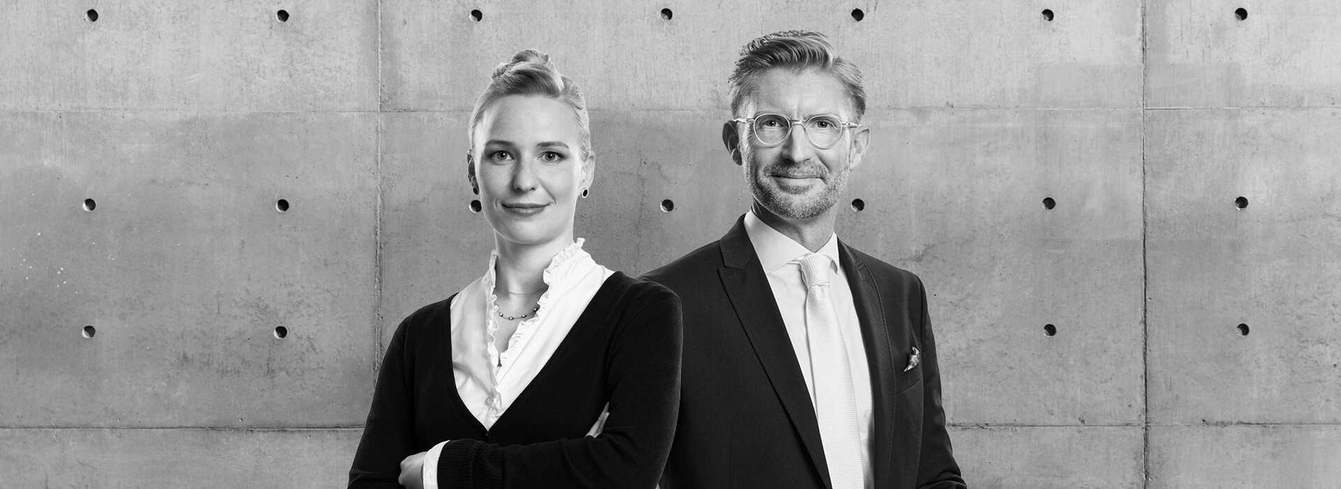 Frau steht neben Mann, der ein Buch hält